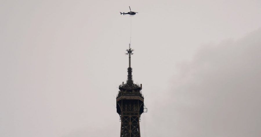 Ein Hubschrauber installiert die neue Antenne auf der Spitze des Eiffelturms.