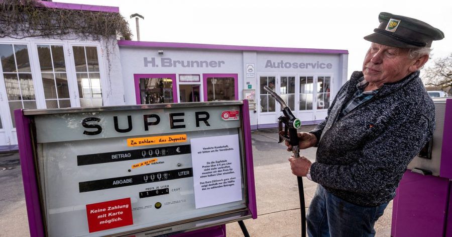 Hans Brunner steht an einer Zapfsäule seiner Tankstelle. Die Tankstelle zeigt Benzin- und Dieselpreise halbliterweise an.
