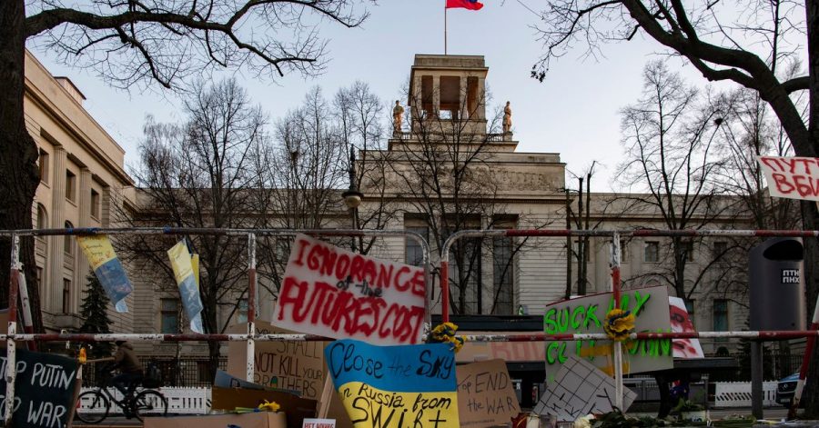 An den Absperrgittern vor der russischen Botschaft in Berlin haben Menschen Plakate angebracht.