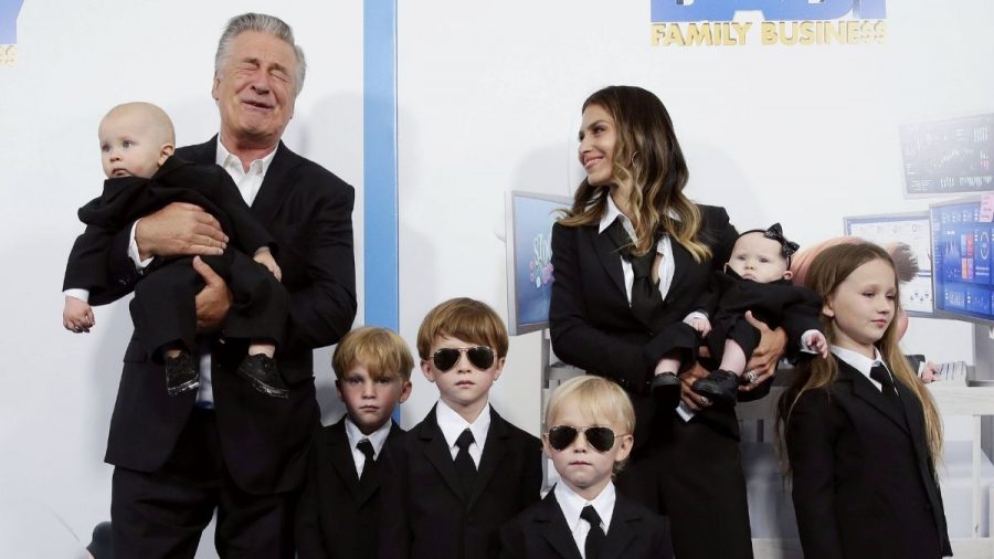 Alec und Hilaria Baldwin mit ihren sechs Kindern alle in dunklen Anzügen mit Sonnenbrillen
