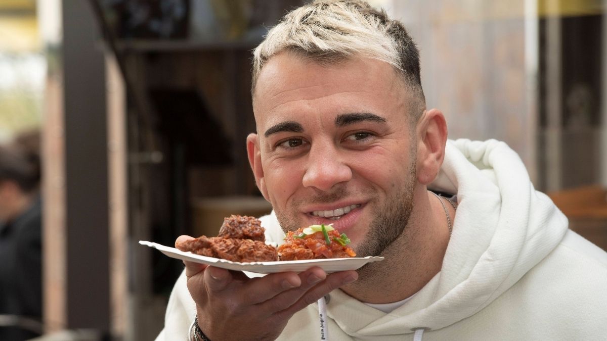 Serkan Yavuz im weißen Pullover promotet Reibekuchen." class="size-full wp-image-1362257