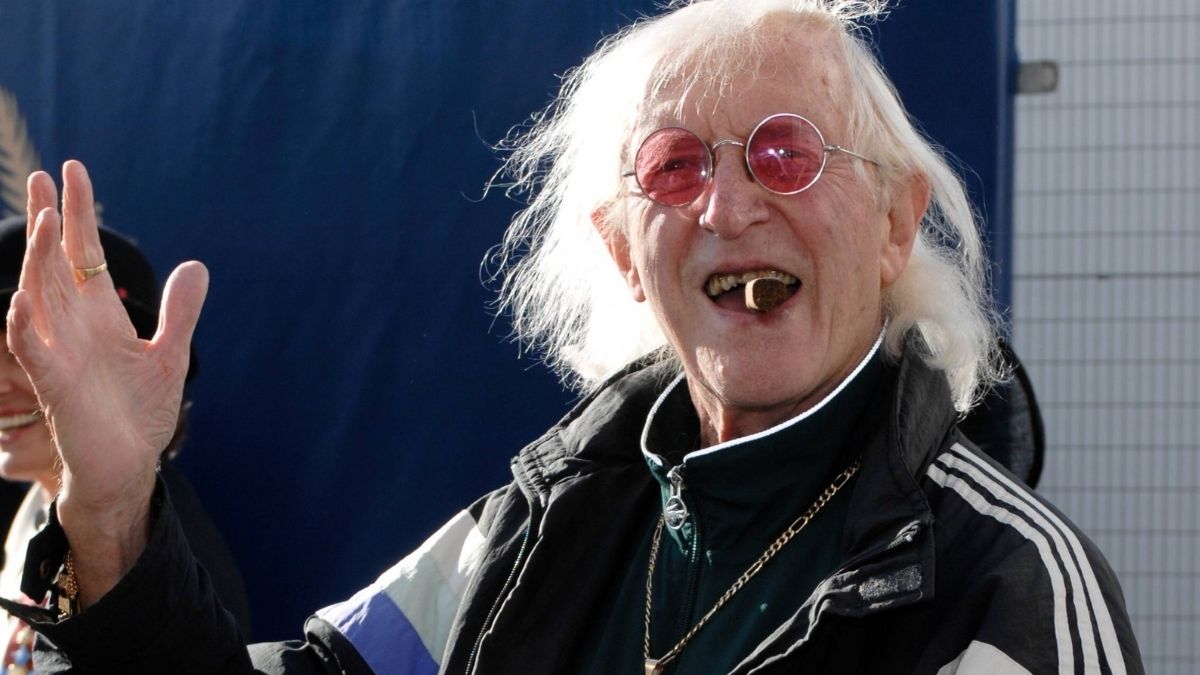Jimmy Savile mit schütterem weißen Haar und dicker Zigarre im Mund" class="size-full wp-image-1387483
