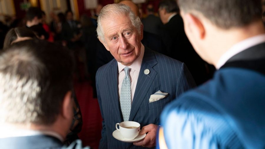 Prinz Charles unterhält sich mit einer Tasse Tee in der Hand