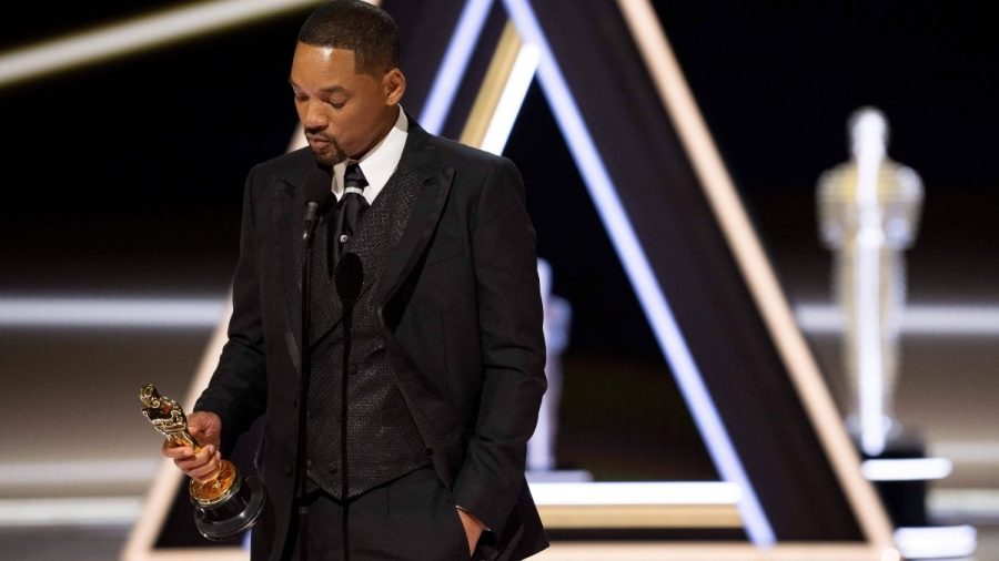 Will Smith im Smoking betrachtet seinen Oscar auf der Bühne