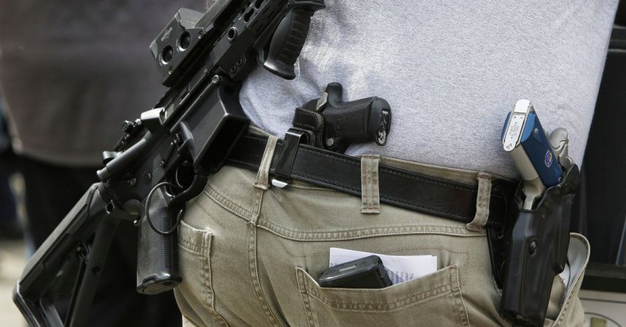 Ein Mann mit mehreren Schusswaffen nimmt an einer Demonstration für das Recht teil, Waffen zu besitzen.