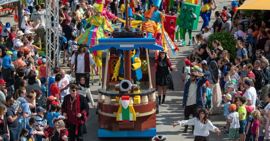 Eine bunte Parade zieht durch den Freizeitpark Legoland.