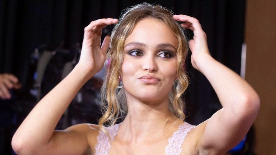 Lily-Rose Depp zieht einen Schmollmund und fasst sich in die Haare.