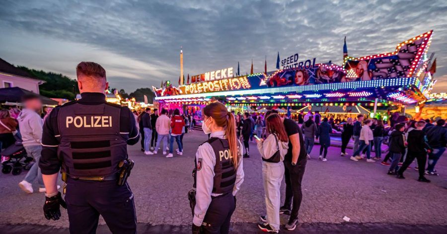Polizeibeamte stehen auf dem Kirmesgelände, wo ein Mann erschossen wurde.