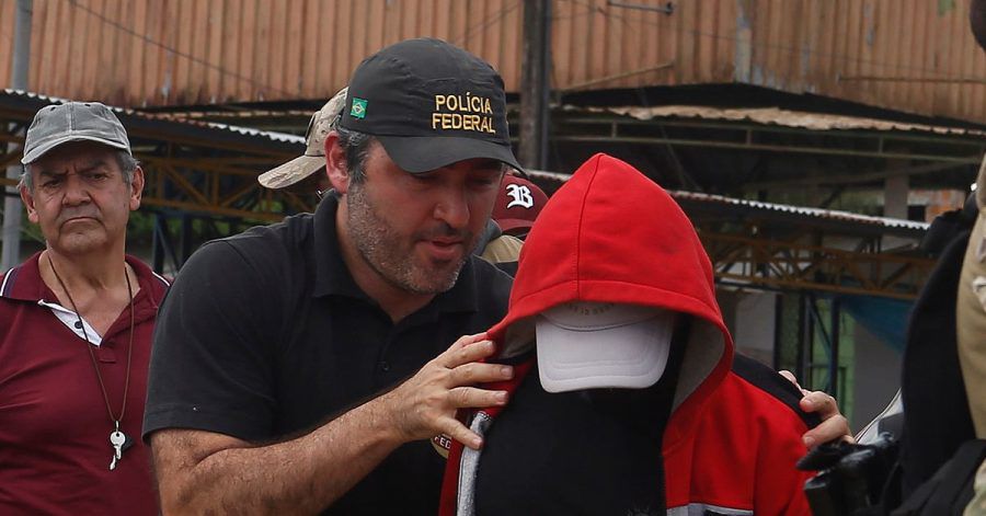 Ein Bundespolizist eskortiert einen Verdächtigen in dem Gebiet, in dem der indigene Experte Bruno Pereira und der freiberufliche britische Journalist Dom Phillips verschwanden.