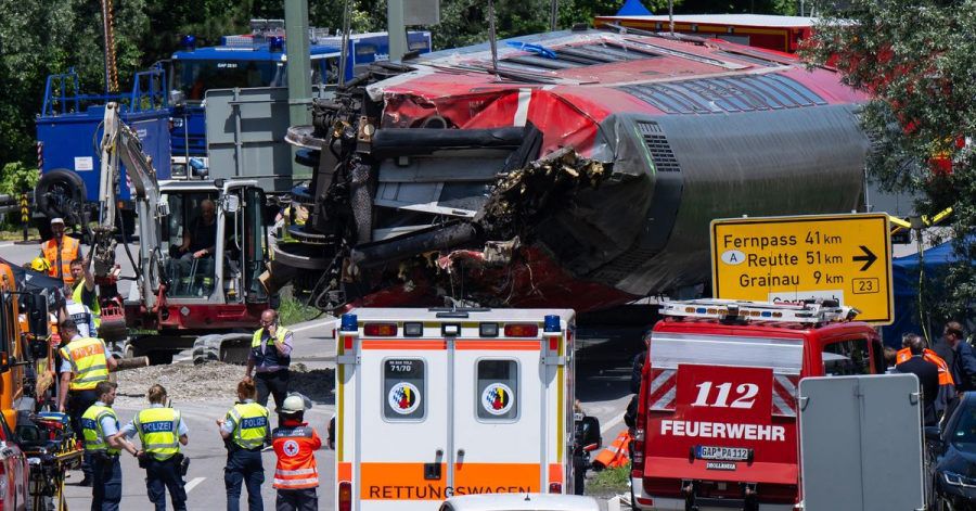 Die Rettungskräfte heben nach dem schweren Zugunglück einen der Waggons an.