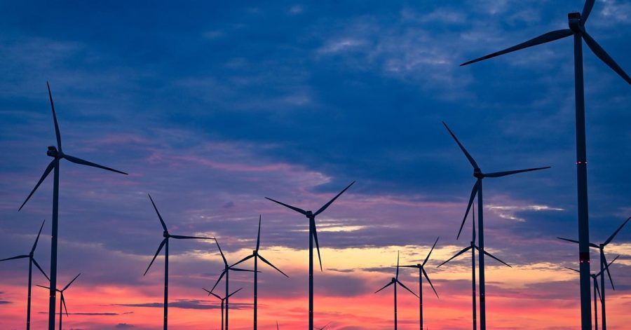 Goldene Stunde In Brandenburg: Kurz vor dem Sonnenaufgang drehen sich die Rotorblätter von Windenergieanlagen im Wind.