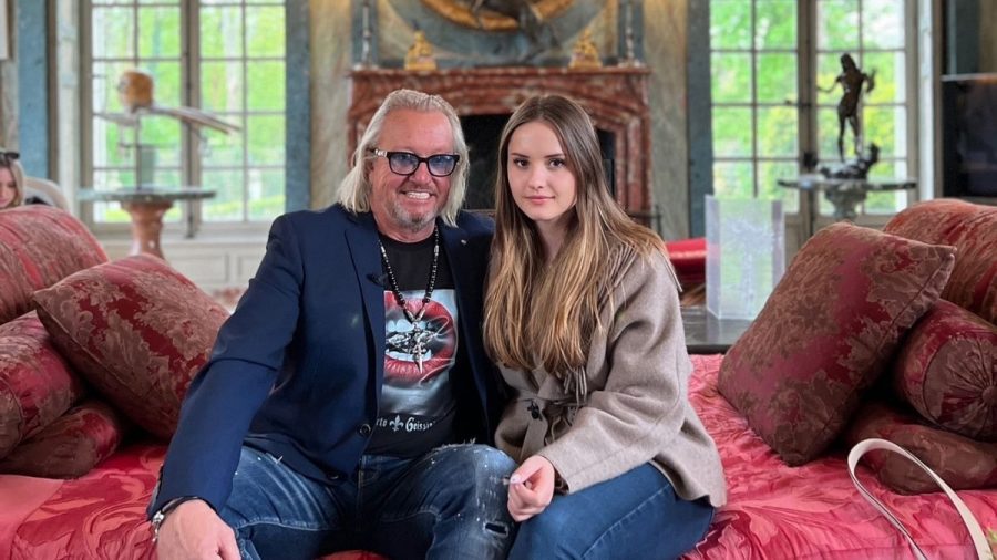 Robert und Shania Geiss auf rotem Sofa in Schloss.