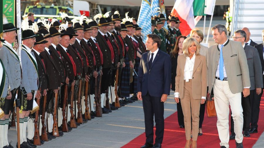 Emmanuel Macron läuft mit seiner Frau Brigitte und Markus Söder die Trachtenparade entlang