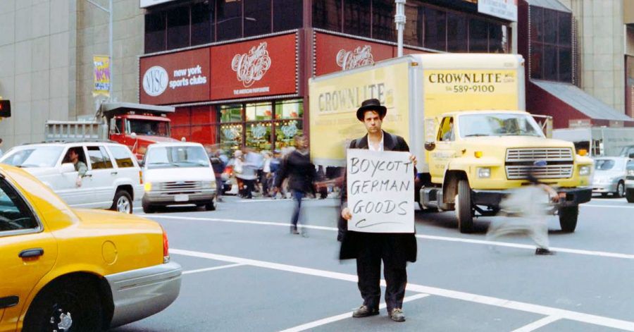 Christoph Schlingensief hält bei einer seiner Aktionen in New York ein Schild mit der Aufschrift "Boycott German Goods".