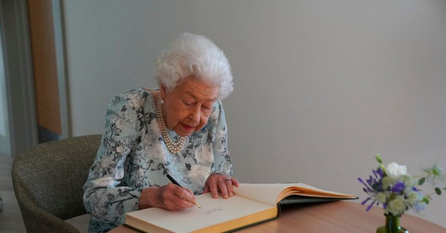 Königin Elizabeth II. trägt sich im Thames Hospizins Besucherbuch ein.