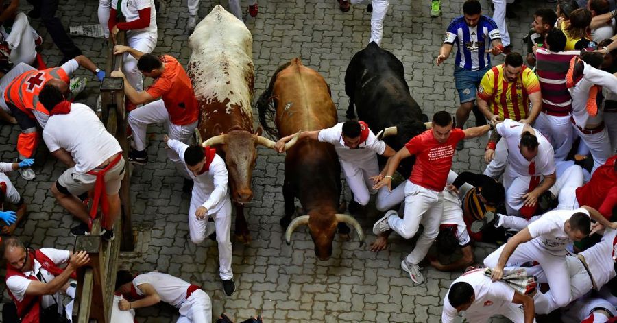 Läufer stürzen während des Stiertreibens beim San-Fermin-Festival.