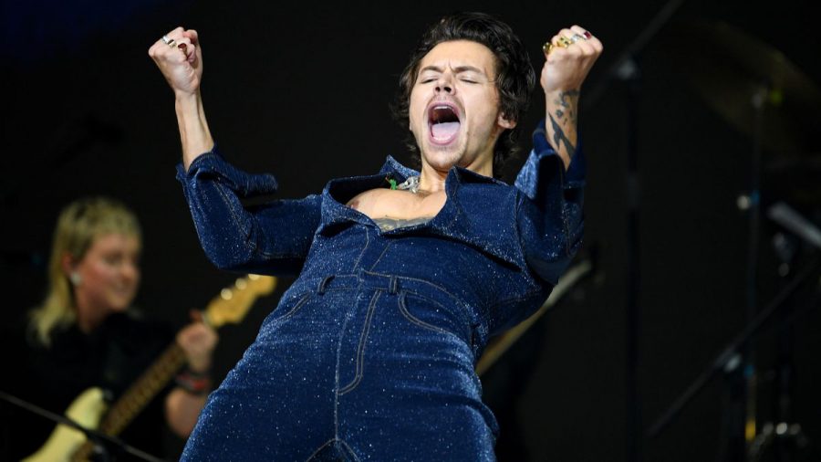 Harry Styles im blauen Jumpsuit in Rockstar-Pose