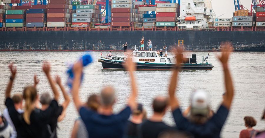 Die Band Fettes Brot tritt auf einem Boot auf der Elbe vor dem Elbstrand auf.