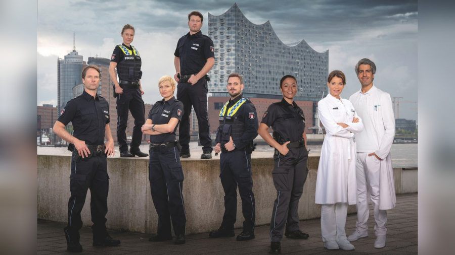 v.li.: Mattes Seeler (Matthias Schloo), Franzi Jung (Rhea Harder-Vennewald), Melanie Hansen (Sanna Englund), Nick Brandt (Raúl Richter), Kris Freiberg (Marc Barthel), Daisy Petersen (Aysha Joy Samuel), Dr. Jasmin Jonas (Gerit Kling) und Dr. Lazar Sharif (Atheer Adel) stehen für "Notruf Hafenkante" vor der Kamera. (tae/spot)