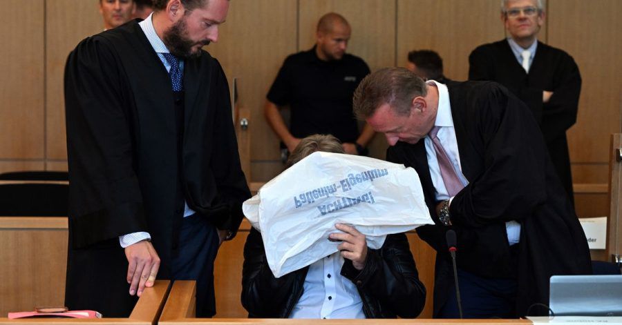 Der Angeklagte (m.) vor Beginn des Prozesses im Gerichtssaal in Aachen.