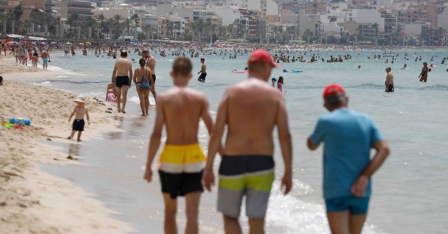 Menschen laufen am Strand von Arenal auf Mallorca.