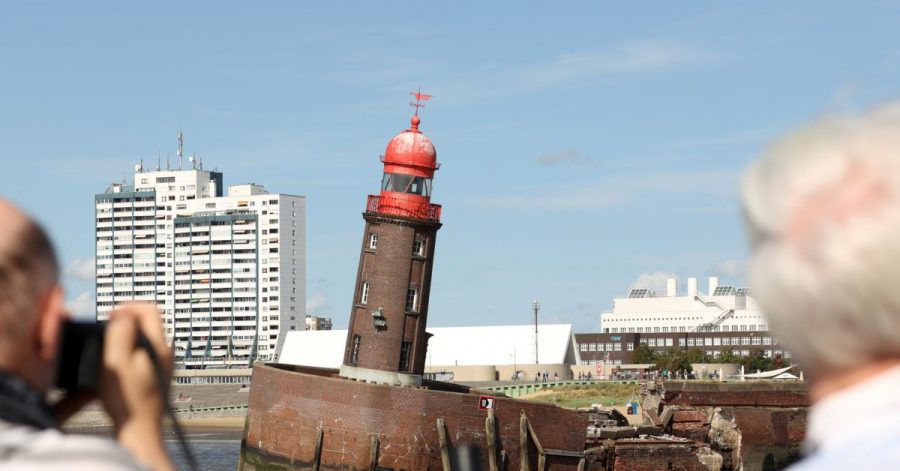 Schaulustige beobachten den abgesackten Moleturm in Bremerhaven.