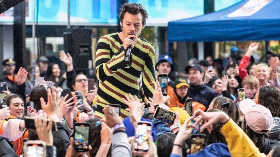 Harry Styles singt im gestreiften Jumpsuit in einer Menschenmenge