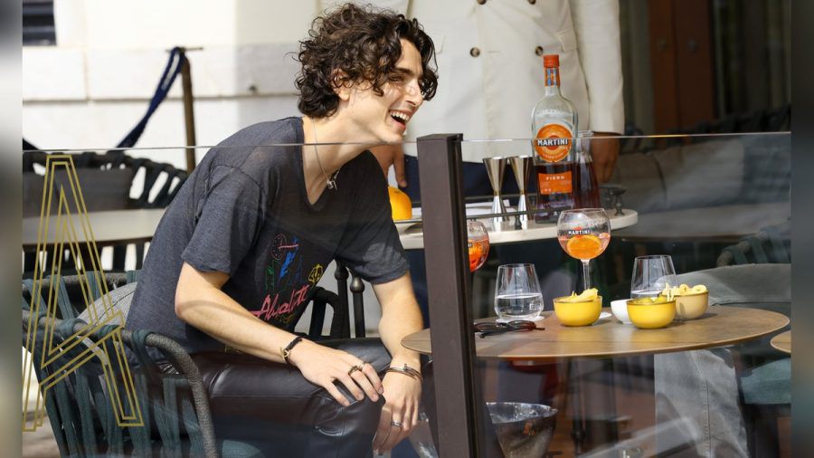 Timothée Chalamet im Vorfeld der Filmfestspiele auf der Terrasse des St. Regis Venice Hotels - betont leger in schwarzer Lederhose und T-Shirt, mit Snacks und einem Martini Fiero & Tonic. (smi/spot)