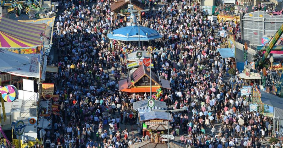 Dich gedrängt schlendern die Besucher bei Sonnenschein über das Oktoberfest-Gelände.