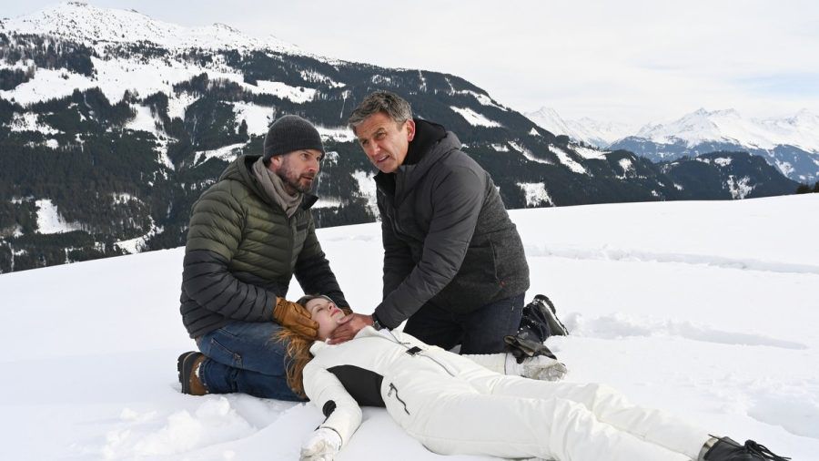 "Der Bergdoktor: Die dunkle Seite des Lichts": Natalie (Emilie Bernsdorf) liegt bewusstlos im Schnee. Ihr Vater Hannes (Simon Böer, li.) und Dr. Martin Gruber (Hans Sigl) kümmern sich um sie. (ili/spot)