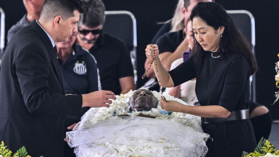 Pelés Witwe Marcia Aoki legt einen Rosenkranz in den Sarg. (smi/spot)