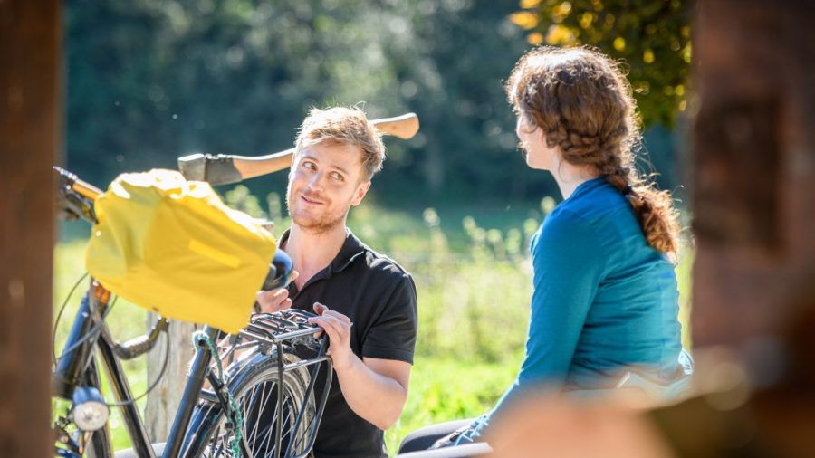 "Sturm der Liebe": Max hilft Liesl mit ihrem Fahrrad. (cg/spot)