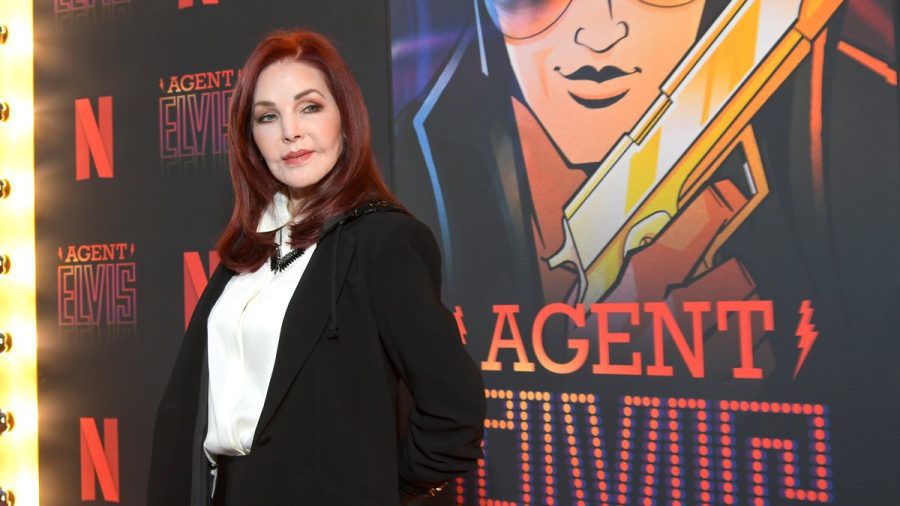 Priscilla Presley posiert vor einem Plakat der Netflix-Zeichentrickserie "Agent Elvis". stephanie.bilges