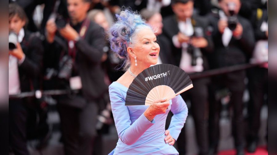 Blaue Haare, blaues Kleid und ein Fächer mit der Aufschrift "Worth It": Dame Helen Mirren bei der Eröffnung der Filmfestspiele von Cannes. (sb/spot)