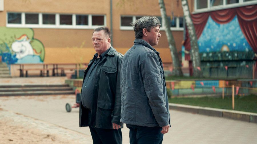 "Polizeiruf 110: Der Dicke liebt": Henry Koitzsch (Peter Kurth) und Michael Lehmann (Peter Schneider) auf dem Schulhof der Otto-Möhwald-Schule. (cg/spot)